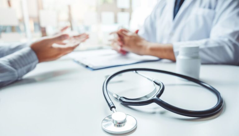 Doctors and patients consulting and diagnostic examining sit and talk. At the table near the window in the hospital medicine concept